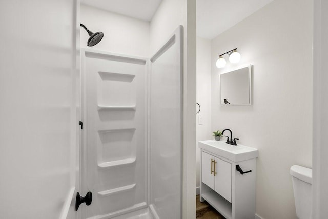 full bathroom featuring walk in shower, toilet, vanity, and wood finished floors