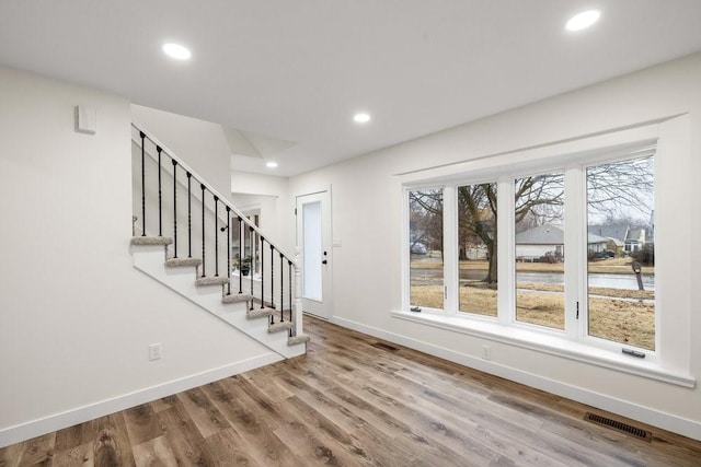 foyer entrance with baseboards, visible vents, recessed lighting, wood finished floors, and stairs