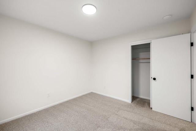 unfurnished bedroom with baseboards, carpet floors, and a closet