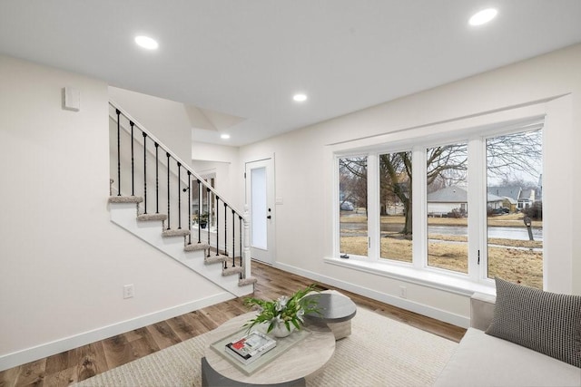 interior space featuring wood finished floors, baseboards, recessed lighting, and stairway