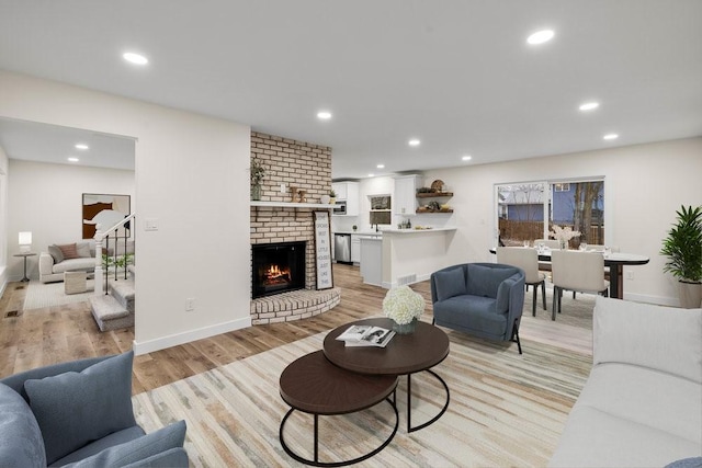 living room with light wood finished floors, a fireplace, and recessed lighting