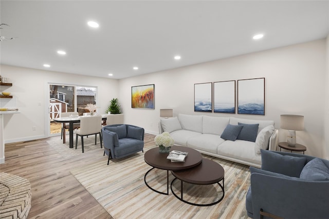 living area featuring baseboards, light wood-style floors, and recessed lighting
