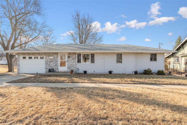 ranch-style home with a garage, stone siding, a front lawn, and concrete driveway