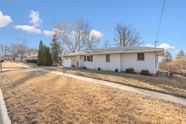 ranch-style house with driveway, an attached garage, and a front yard