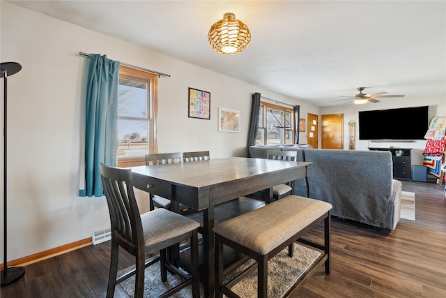 dining area featuring ceiling fan, baseboards, and dark wood finished floors