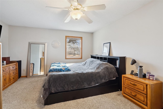 bedroom with light colored carpet, ceiling fan, and baseboards