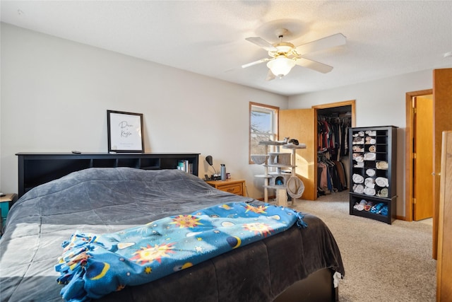 carpeted bedroom with ceiling fan, a textured ceiling, and a closet