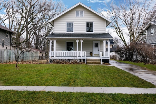 view of front facade featuring a porch, a front yard, and fence