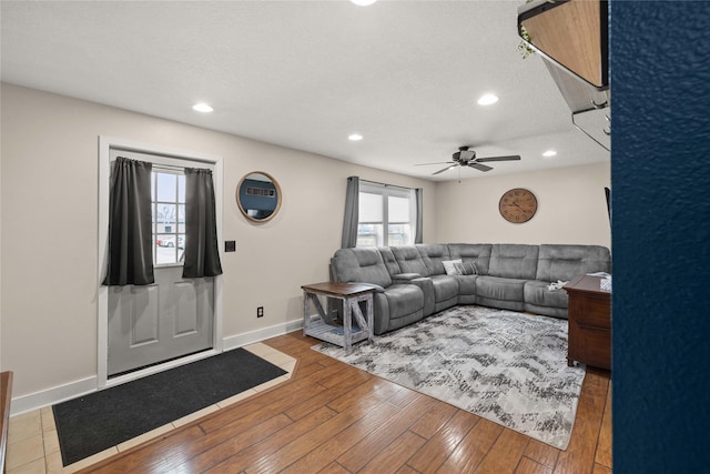 living area featuring baseboards, a ceiling fan, wood-type flooring, a textured ceiling, and recessed lighting