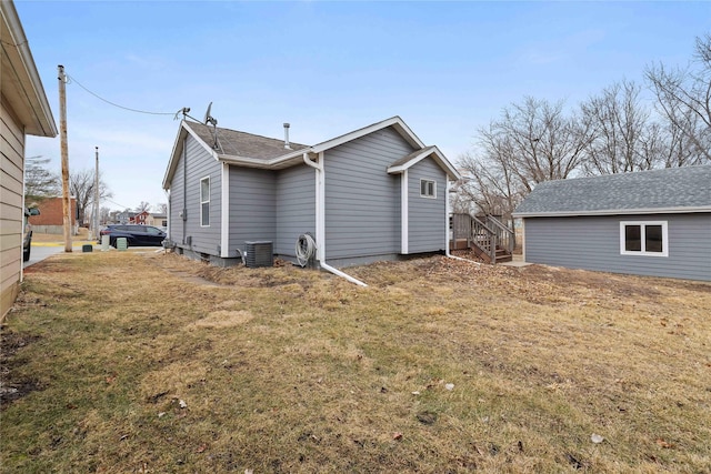 back of house with central AC and a lawn