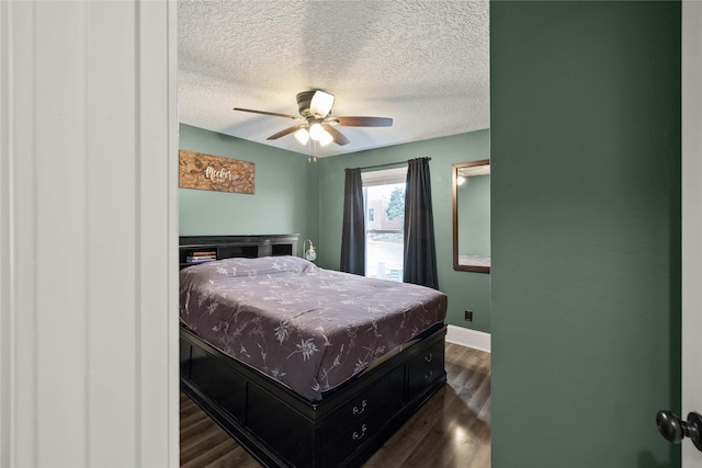 bedroom featuring a ceiling fan, dark wood-style flooring, a textured ceiling, and baseboards