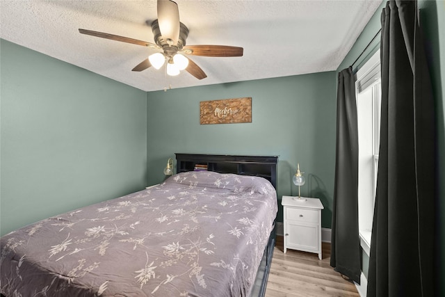 bedroom featuring a textured ceiling, ceiling fan, and wood finished floors