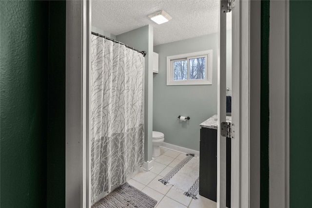 full bath featuring toilet, vanity, a textured ceiling, baseboards, and tile patterned floors