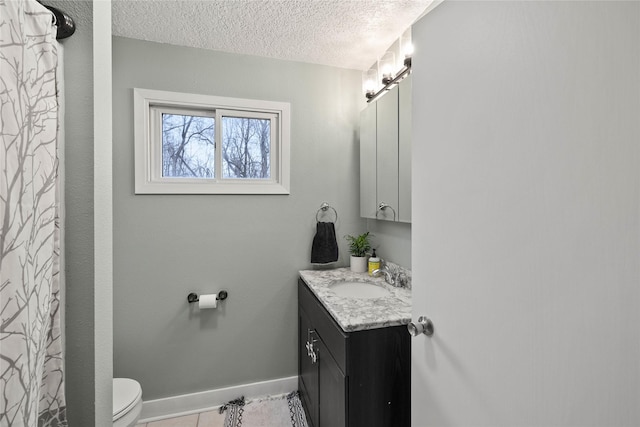 bathroom featuring baseboards, toilet, tile patterned floors, a textured ceiling, and vanity