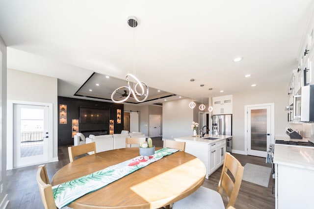 dining room featuring baseboards, a raised ceiling, dark wood-type flooring, and recessed lighting