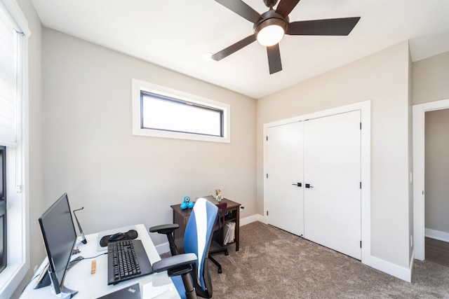 carpeted office with ceiling fan and baseboards