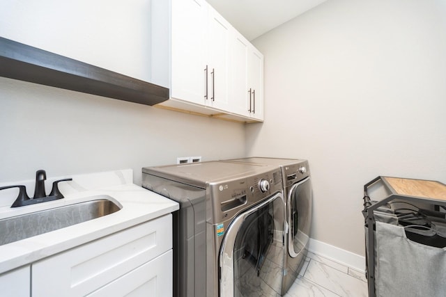 washroom featuring a sink, baseboards, marble finish floor, cabinet space, and washing machine and clothes dryer