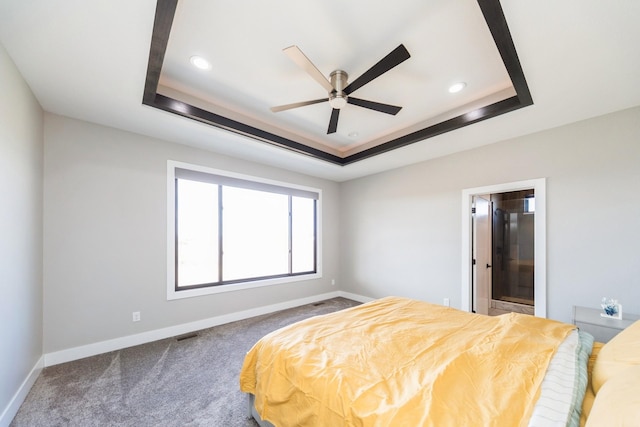 bedroom featuring a tray ceiling, dark carpet, baseboards, and recessed lighting