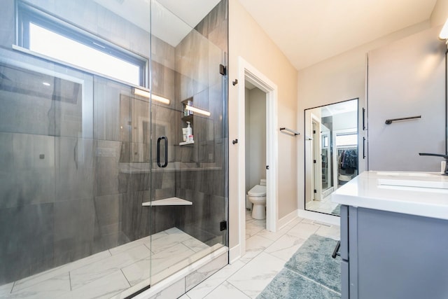 full bathroom featuring toilet, marble finish floor, a shower stall, and baseboards