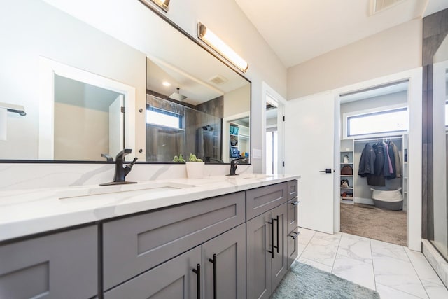 bathroom featuring marble finish floor, a stall shower, and a sink