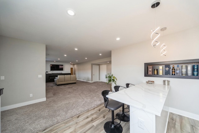 dining space with light wood-type flooring, baseboards, light colored carpet, and recessed lighting