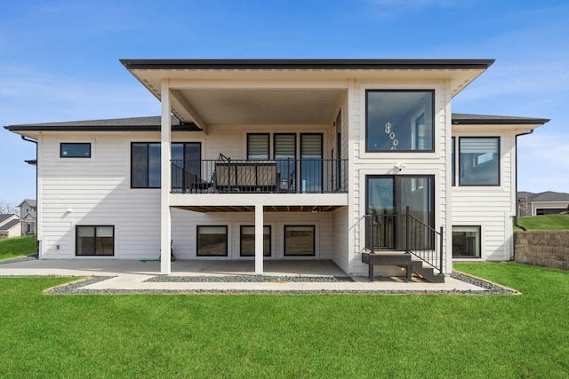 back of house featuring entry steps, a lawn, a patio area, and a balcony