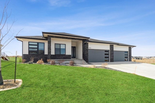 prairie-style home with a garage, concrete driveway, stone siding, stucco siding, and a front yard