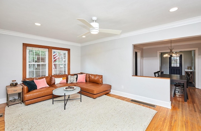 living area with baseboards, light wood-style flooring, visible vents, and crown molding