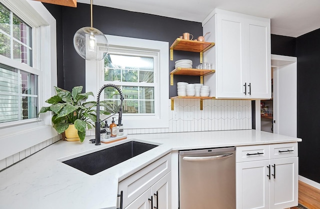 kitchen featuring a sink, plenty of natural light, open shelves, and dishwasher