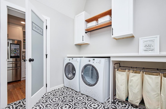 laundry room with cabinet space, independent washer and dryer, and baseboards