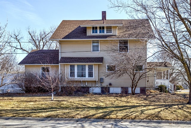 view of home's exterior with a shingled roof, a chimney, and a lawn