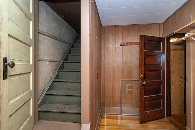 stairway featuring wooden walls and wood finished floors