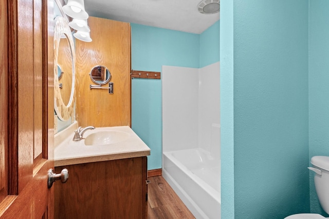 bathroom featuring toilet, wood finished floors, and vanity