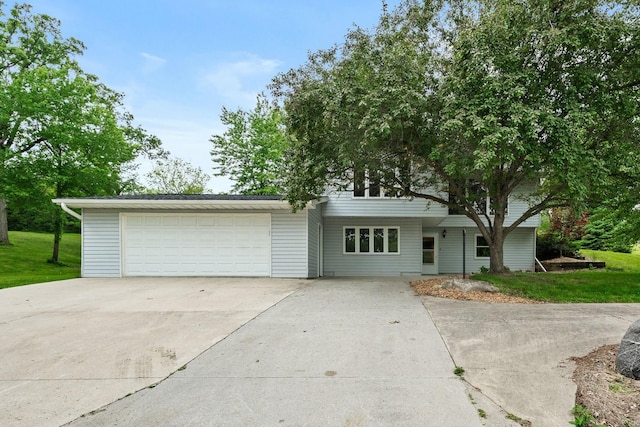 view of front of house with a garage, concrete driveway, and a front yard