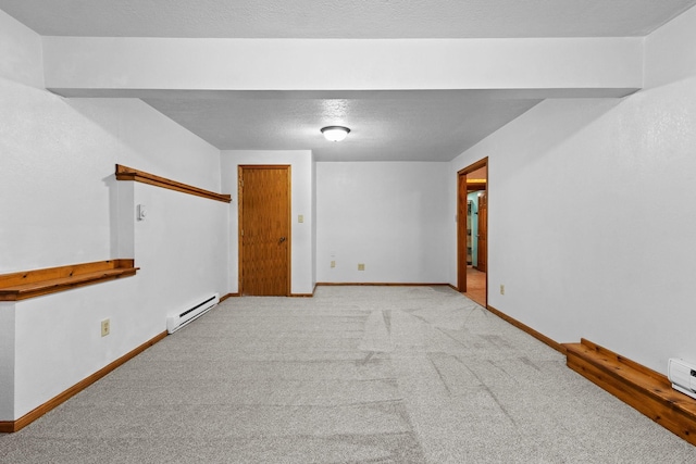 spare room featuring light carpet, baseboard heating, a textured ceiling, and baseboards