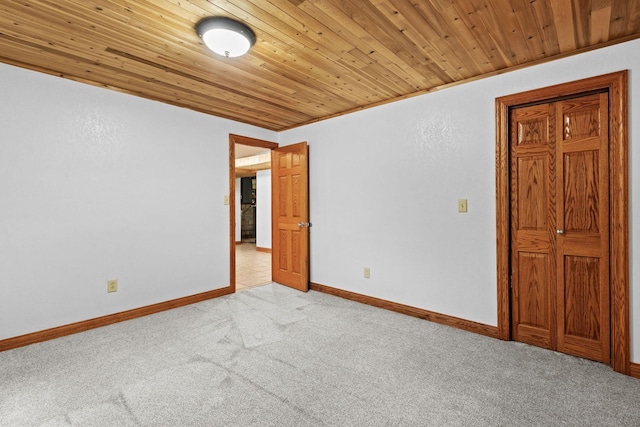 unfurnished room featuring wooden ceiling, baseboards, and light colored carpet