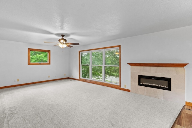 unfurnished living room featuring baseboards, a fireplace, and a healthy amount of sunlight