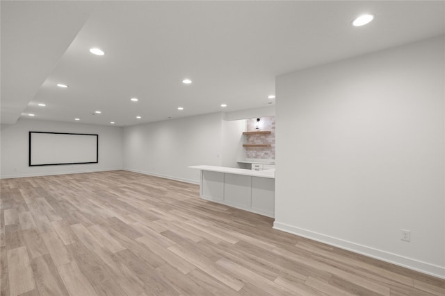 unfurnished living room featuring recessed lighting, light wood-type flooring, and baseboards