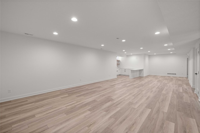 below grade area featuring recessed lighting, light wood-type flooring, baseboards, and visible vents