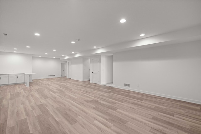 finished basement featuring visible vents, recessed lighting, baseboards, and light wood finished floors