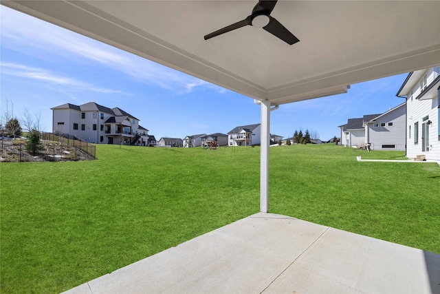 view of yard with a residential view, a patio, and ceiling fan