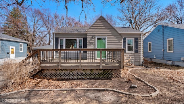 back of property with roof with shingles and a wooden deck