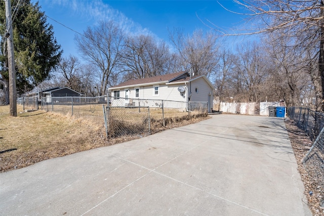 view of side of property featuring concrete driveway and fence