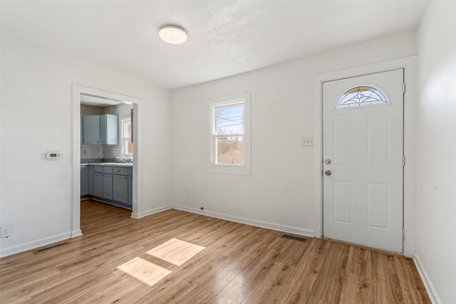 entryway with light wood-style flooring, visible vents, and baseboards