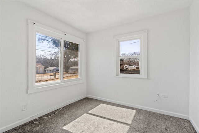 spare room featuring baseboards and carpet flooring