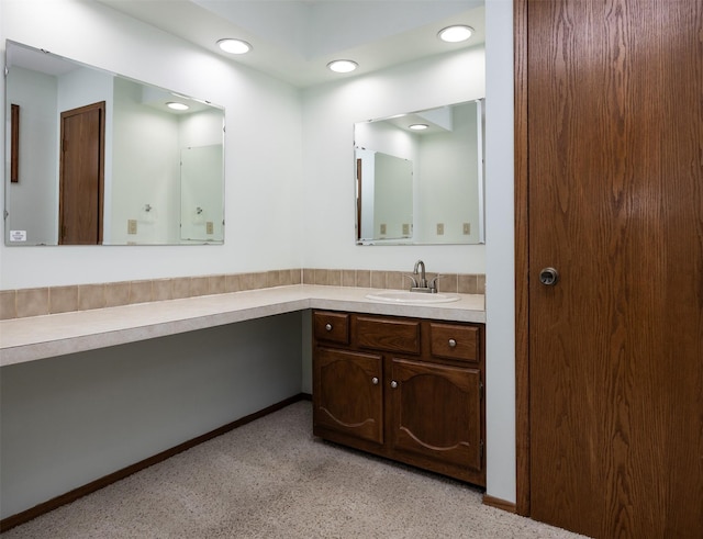 bathroom featuring carpet, vanity, and baseboards