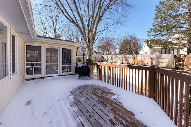 snow covered deck featuring a sunroom, fence, and grilling area