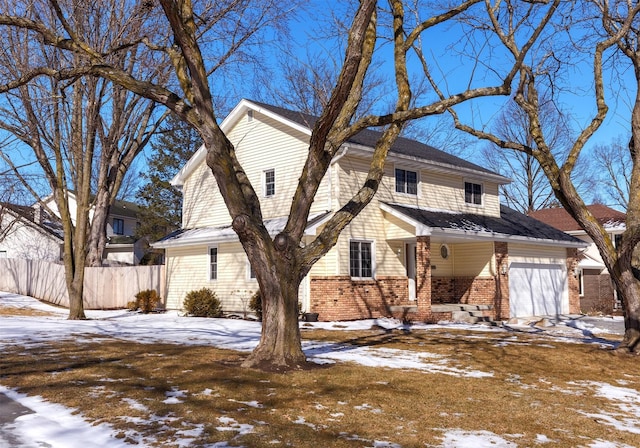 view of snowy exterior with fence and brick siding