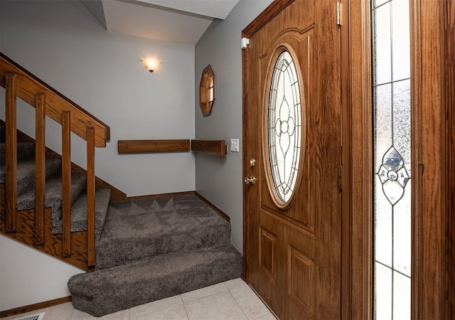 entryway featuring light colored carpet, stairway, baseboards, and light tile patterned flooring