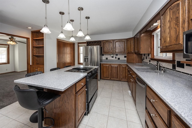 kitchen with stainless steel appliances, a sink, a kitchen breakfast bar, a center island, and tasteful backsplash